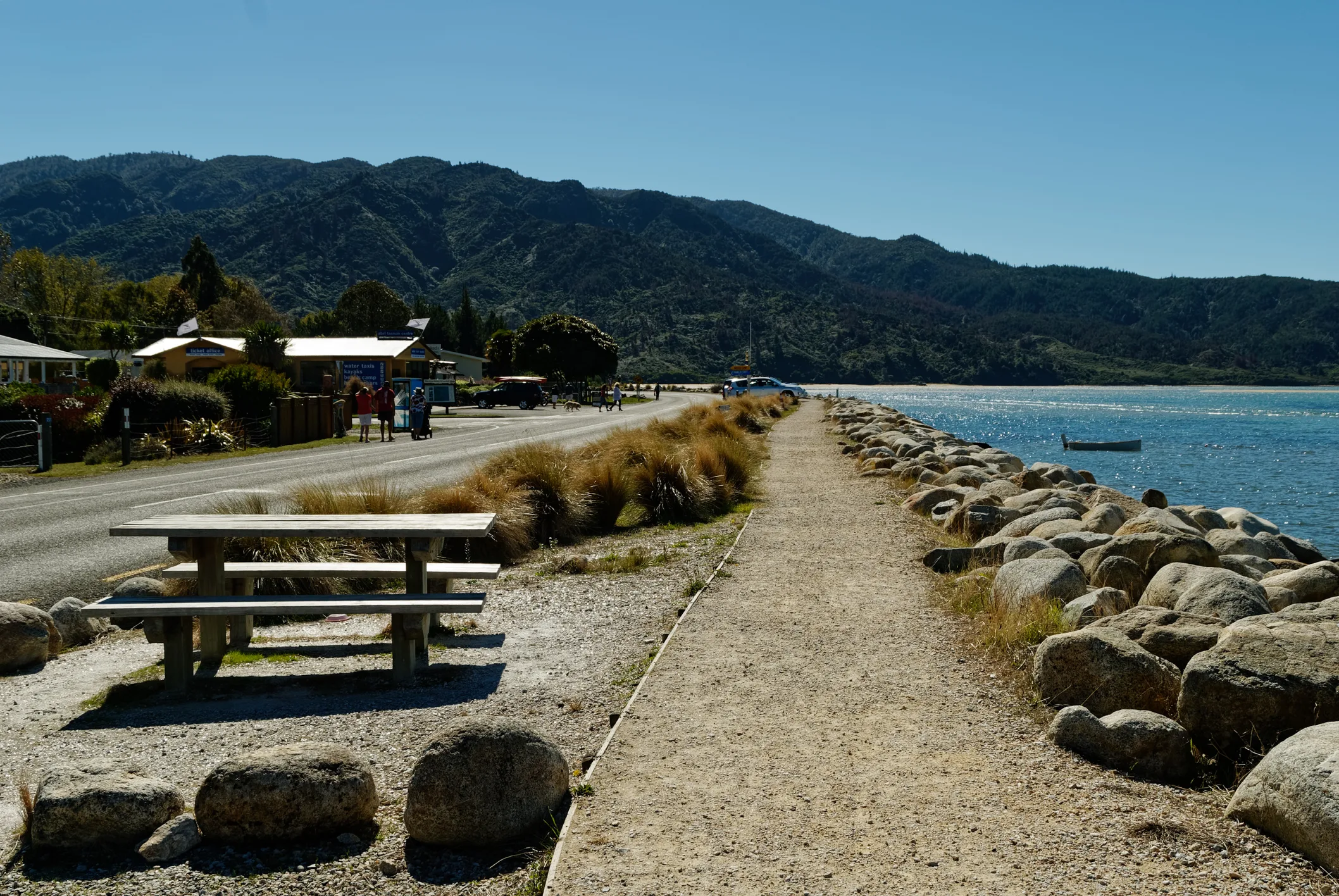 Mārahau waterfront walkway, village buildings and Tasman Bay